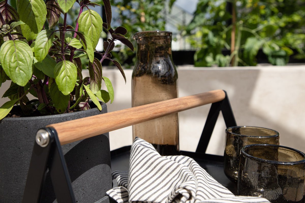 Gartentisch Moyo - e Beistelltisch mat enger quadratescher Dëschplack an engem Grëff aus Teakholz