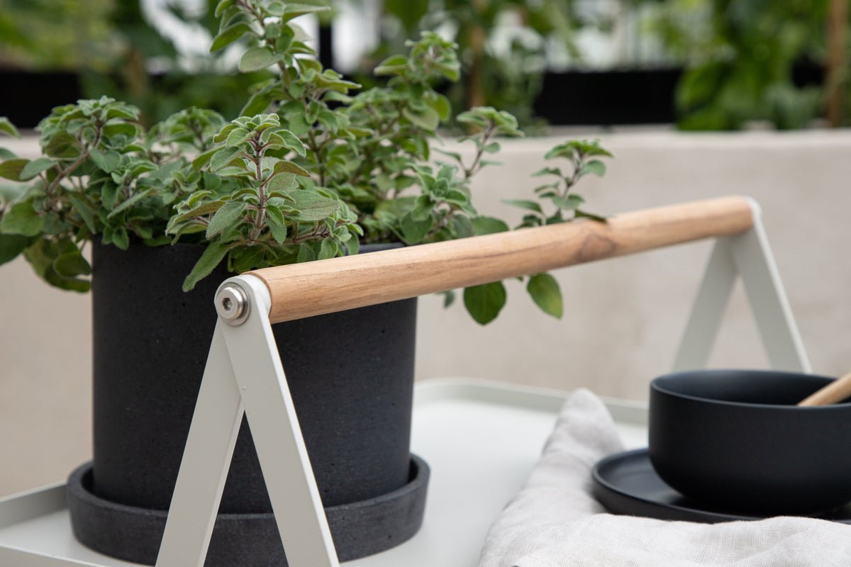 Gartentisch Moyo - e Beistelltisch mat enger quadratescher Dëschplack an engem Grëff aus Teakholz